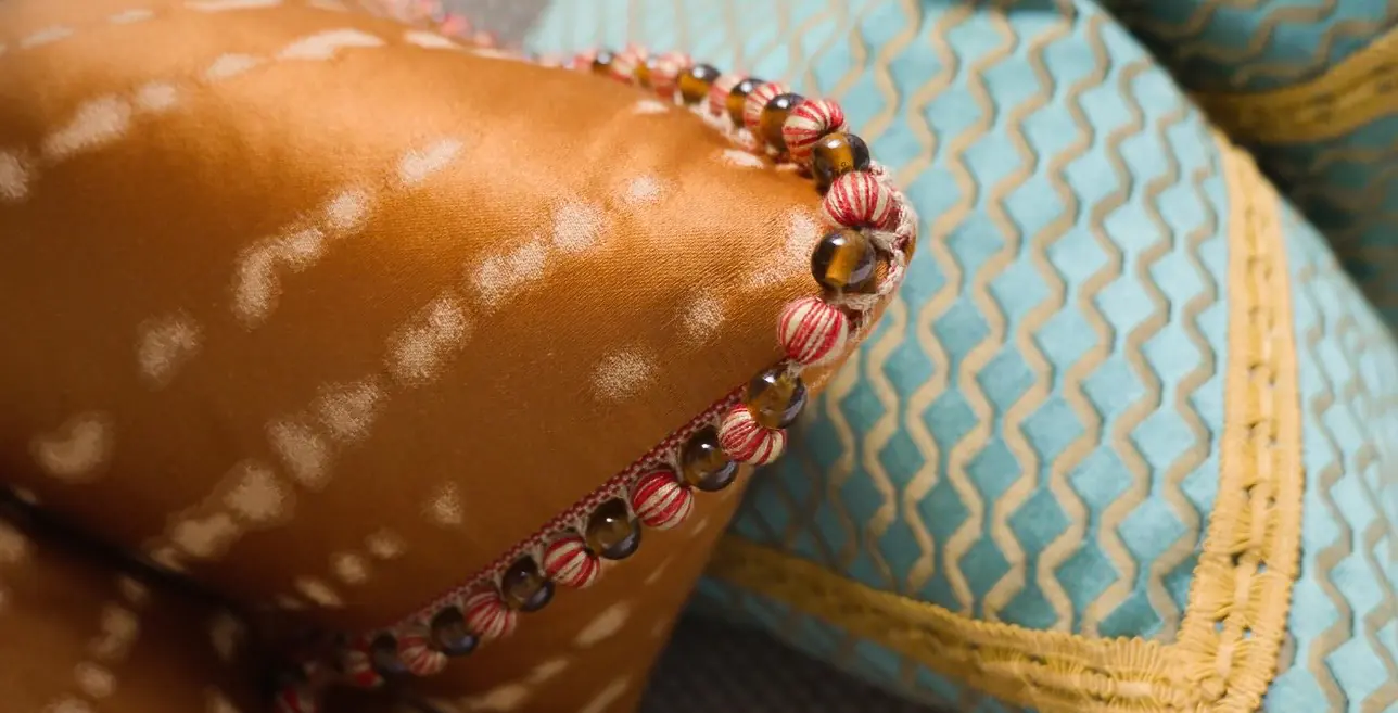 Close-up of an embroidered cushion on patterned fabric